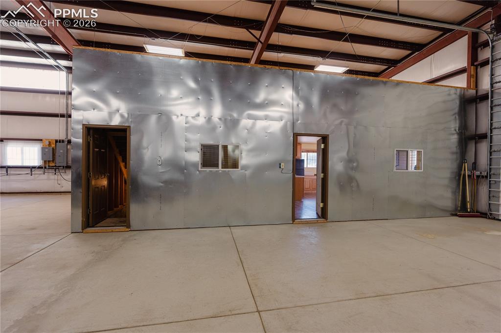Image 34 of 42: The property features a spacious interior with concrete flooring and a high