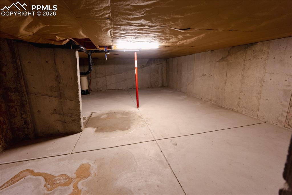 Image 35 of 43: Unfinished basement providing expansive space with concrete walls and floor