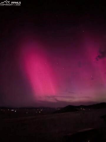 Image 37 of 43: The property offers expansive views of the night sky, featuring a vibrant m