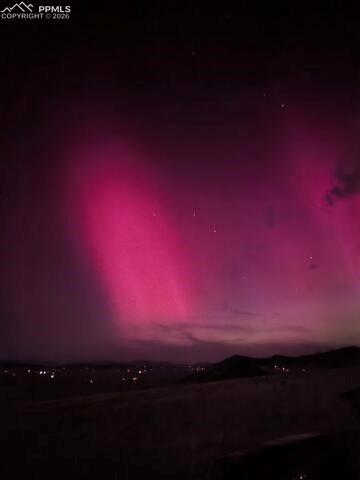 Image 37 of 42: The property offers expansive views of the night sky, featuring a vibrant m