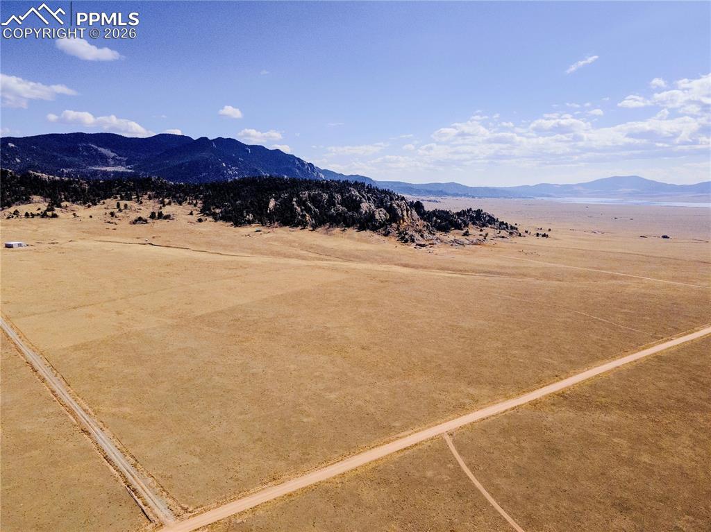 Image 39 of 43: Expansive natural landscape with a dirt road, offering views of distant mou