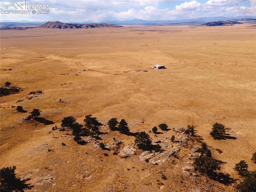 Image 42 of 42: Expansive property featuring a vast, open landscape with a distant building