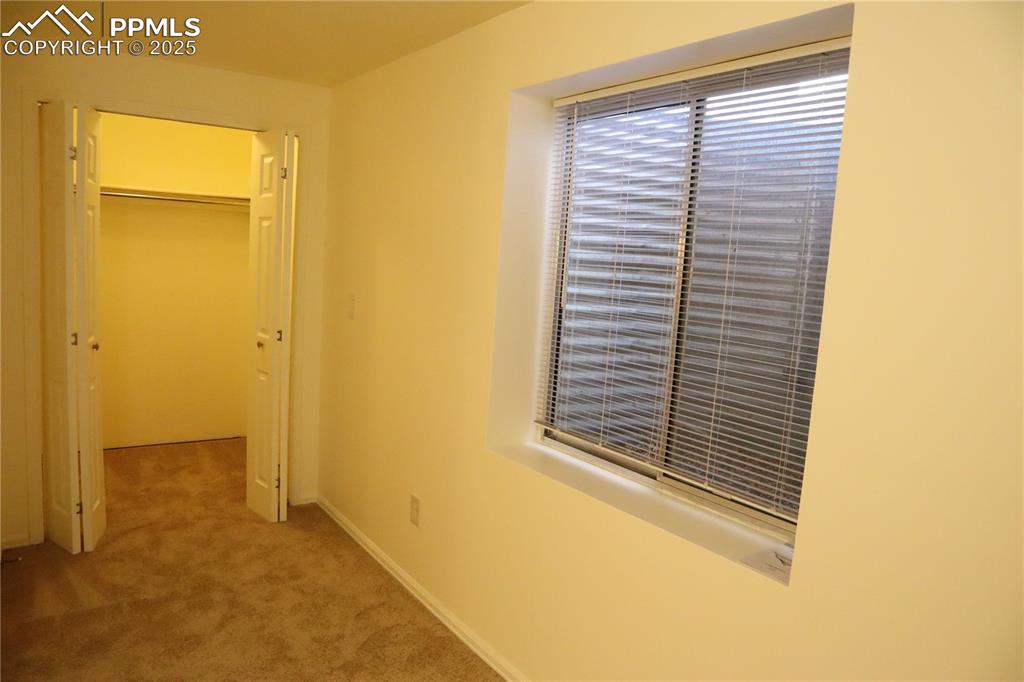 Image 29 of 34: Unfurnished bedroom with light colored carpet and baseboards