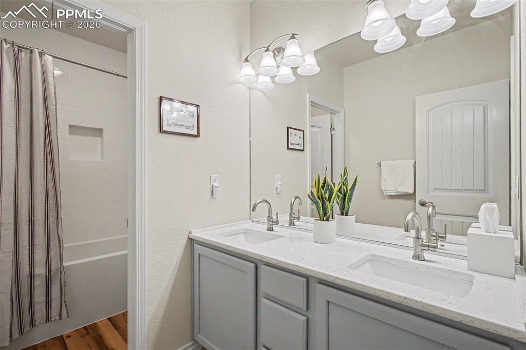 Image 34 of 45: Full bathroom in basement with dual sinks