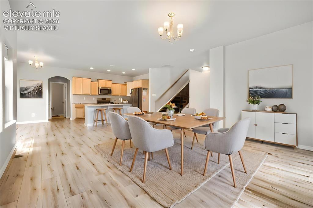 Image 11 of 33: Virtually Staged
Open-concept living area with wood-finish flooring exten