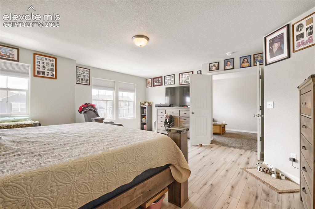 Image 14 of 32: Light wood-finish flooring throughout, featuring a full-light patio door op