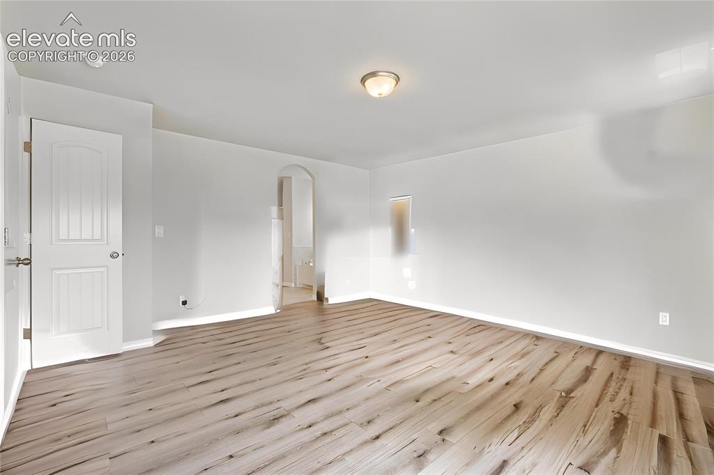Image 15 of 33: Spacious room featuring wood-finish flooring and a neutral color palette