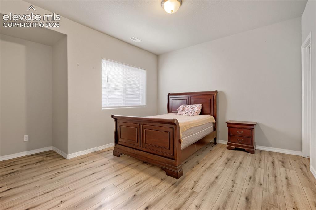 Image 22 of 33: Light wood-finish flooring complements the neutral wall color