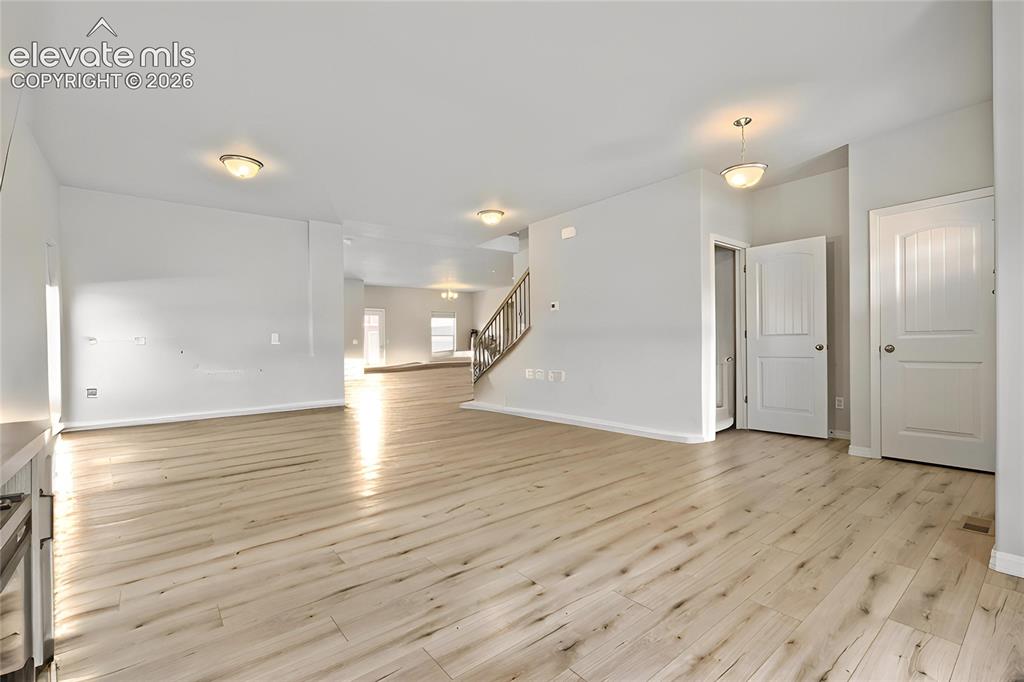 Image 3 of 33: Spacious interior featuring light wood-finish flooring, neutral wall tones,