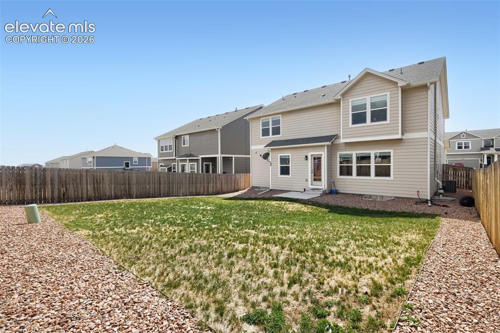 Image 30 of 33: Expansive backyard featuring a wood fence, gravel landscaping, and a concre