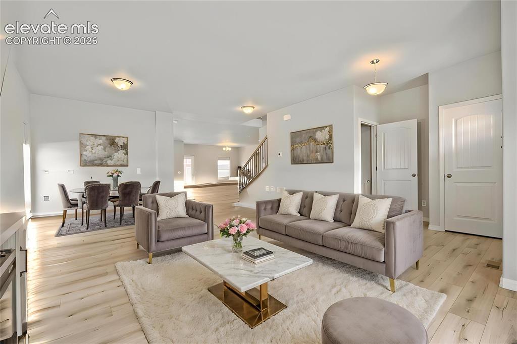 Image 4 of 33: Expansive living area featuring light wood-finish flooring, recessed lighti