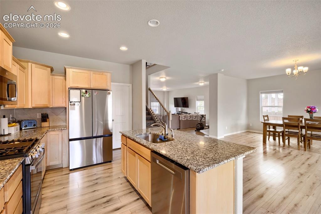 Image 7 of 33: Kitchen featuring light wood cabinetry, granite countertops, and stainless