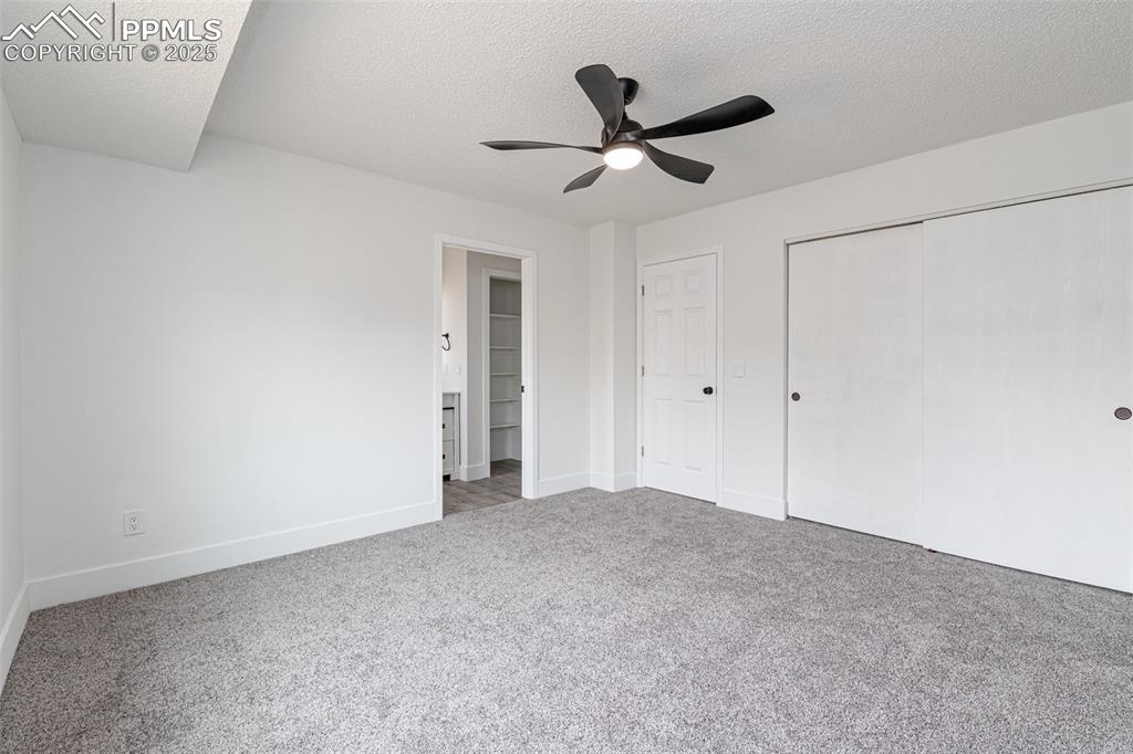 Image 14 of 33: Unfurnished bedroom featuring a textured ceiling, carpet flooring, a closet