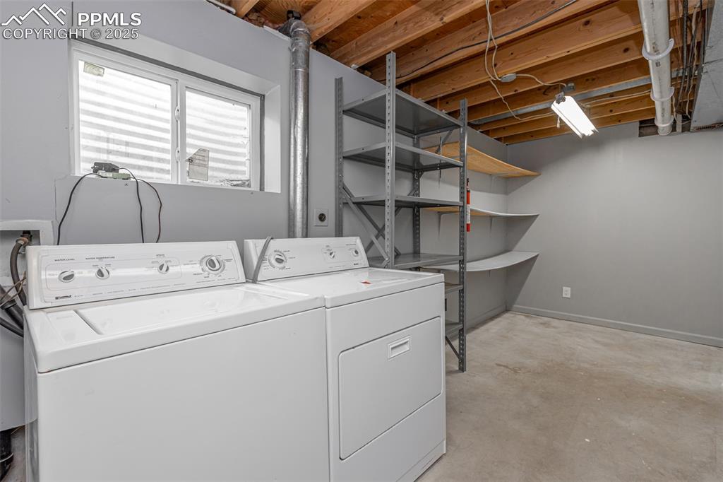 Image 24 of 33: Laundry area featuring unfinished concrete floors and washer and dryer