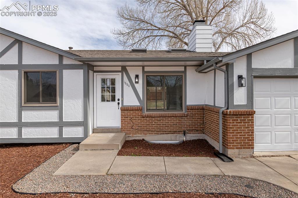Image 3 of 33: Entrance to property featuring stucco siding, brick siding, roof with shing