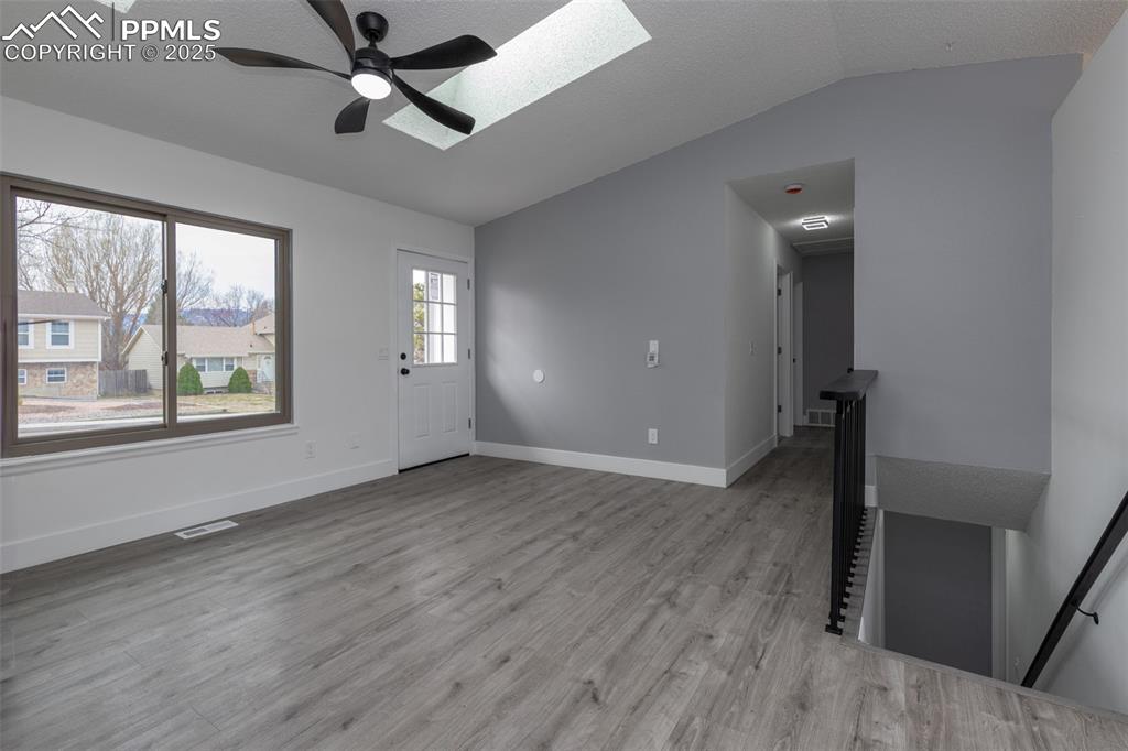 Image 6 of 33: Foyer with a skylight, ceiling fan, lofted ceiling, light wood finished flo