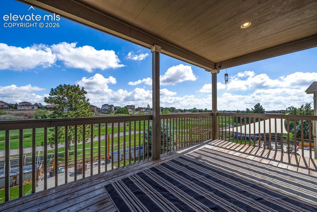 Image 10 of 50: Expansive covered deck featuring wood decking, wood balusters, and a recess