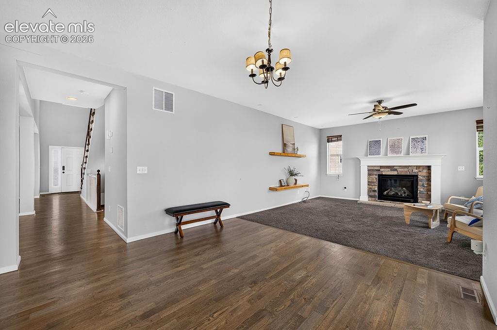 Image 19 of 50: Wood-finish flooring, recessed lighting, ceiling fan, and a fireplace with