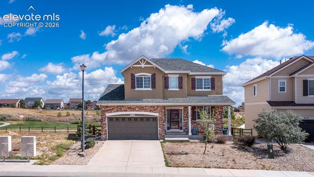 Image 2 of 50: Two-story residence featuring a covered front porch, attached two-car garag