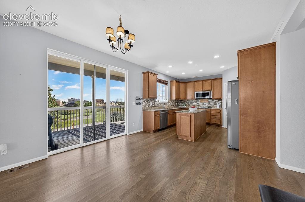 Image 21 of 50: Wood-finish flooring throughout, kitchen with wood cabinetry, stainless ste