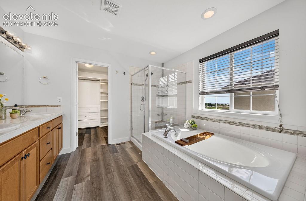 Image 28 of 50: Bathroom featuring a double vanity with wood cabinetry, a glass-enclosed sh