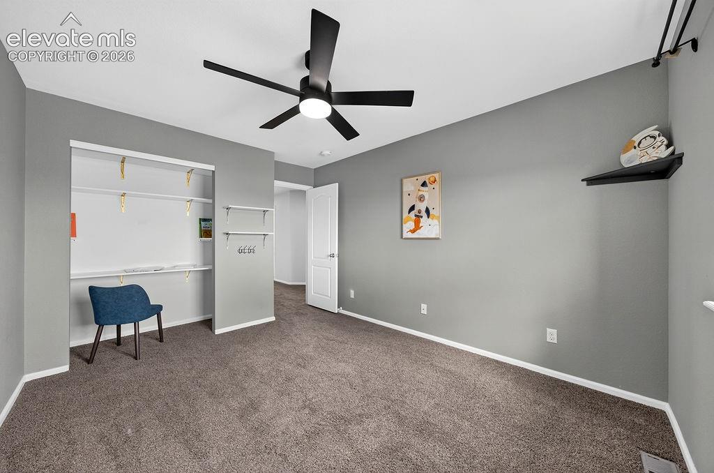 Image 33 of 50: Dark gray carpeting, gray painted walls, and a black ceiling fan with integ