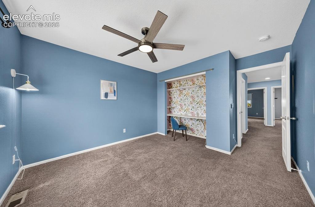 Image 36 of 50: Wall-to-wall carpeting, ceiling fan with integrated lighting, built-in shel