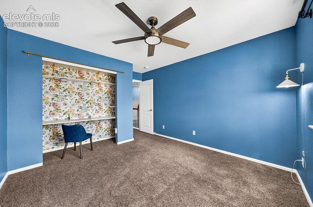 Image 37 of 50: Built-in shelving with floral wallpaper, contemporary ceiling fan, and wall