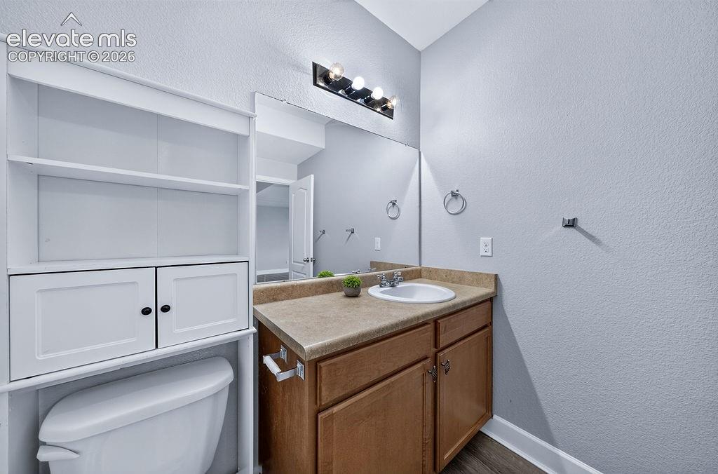 Image 40 of 50: Vanity with an integrated sink and laminate countertop, wood-finish floorin