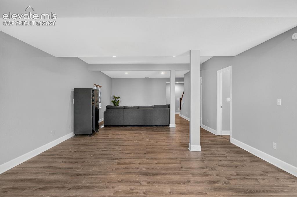 Image 45 of 50: Wood-finish flooring with white trim, recessed lighting, and neutral wall t