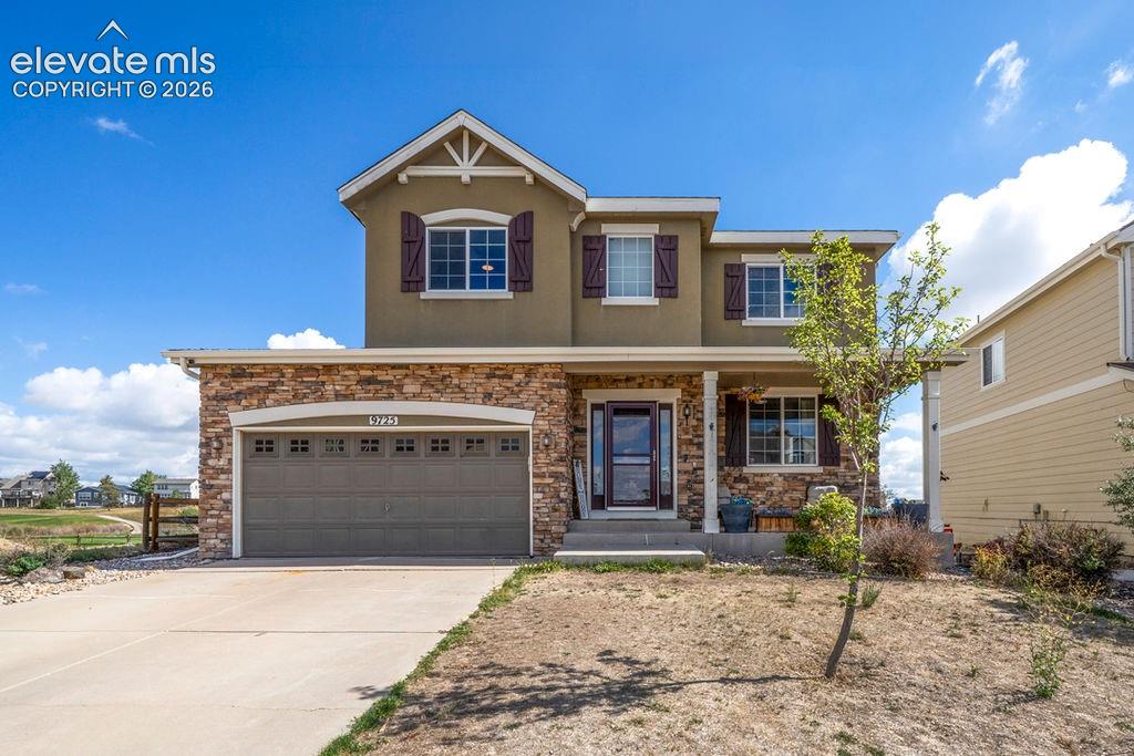Image 47 of 50: Stucco exterior with stone accents, two-car garage, covered entry, and mult