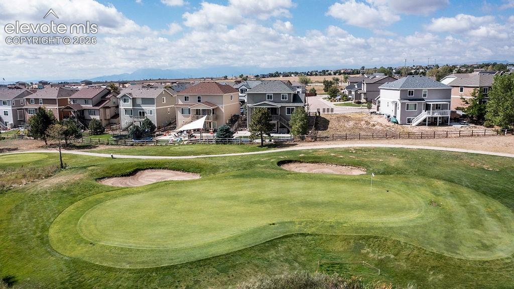 Image 5 of 50: Expansive golf course green with sand traps and a flagstick