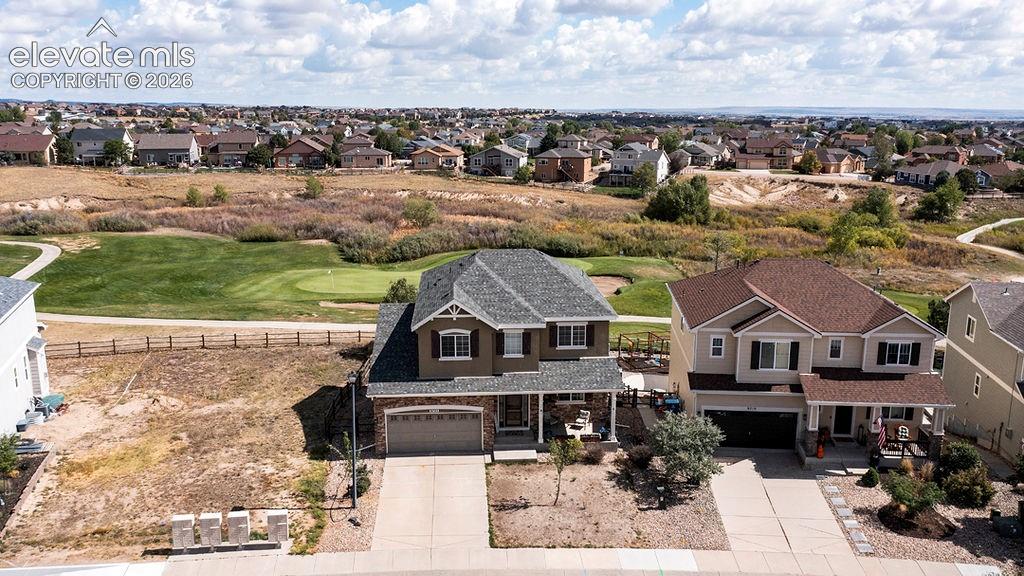 Image 7 of 50: Two-story residence with a stone and siding exterior, front-facing garage, 