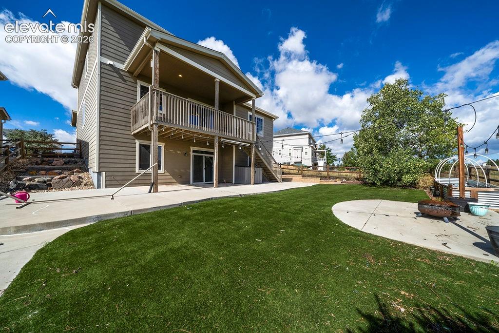 Image 8 of 50: Expansive backyard featuring a manicured lawn, concrete patio, a second-sto