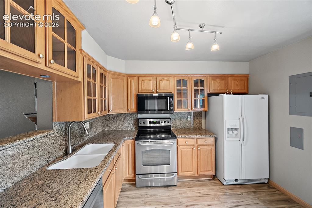 Image 11 of 29: Living area featuring wood-finish flooring, a white paneled entry door, and
