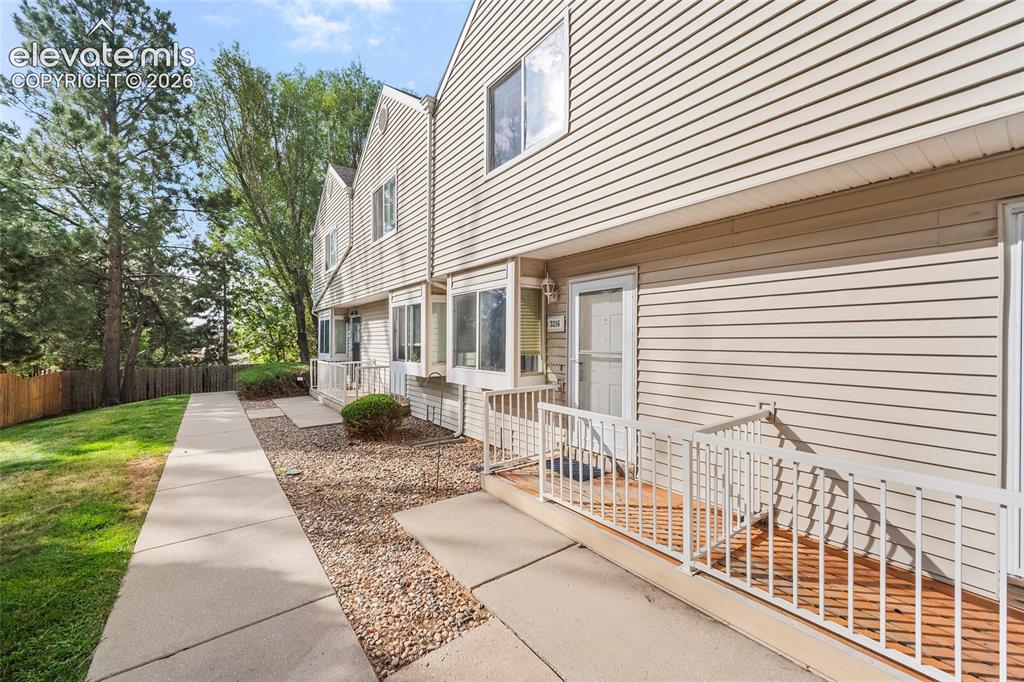 Image 2 of 29: Exterior siding, front entry door with storm door, wood-finish decking, and
