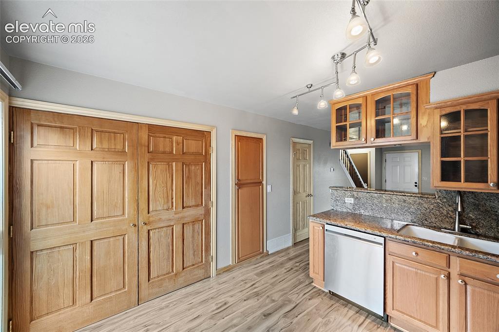 Image 5 of 29: Kitchen featuring wood-finish flooring, granite countertops, wood cabinetry