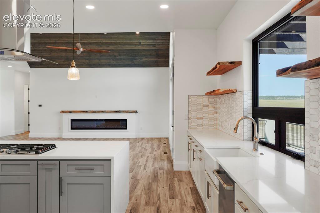 Image 12 of 41: Kitchen featuring a gas range, white countertops, and gray cabinetry