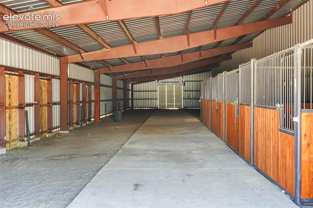 Image 28 of 41: Metal-framed structure featuring multiple stalls with wood-finish paneling