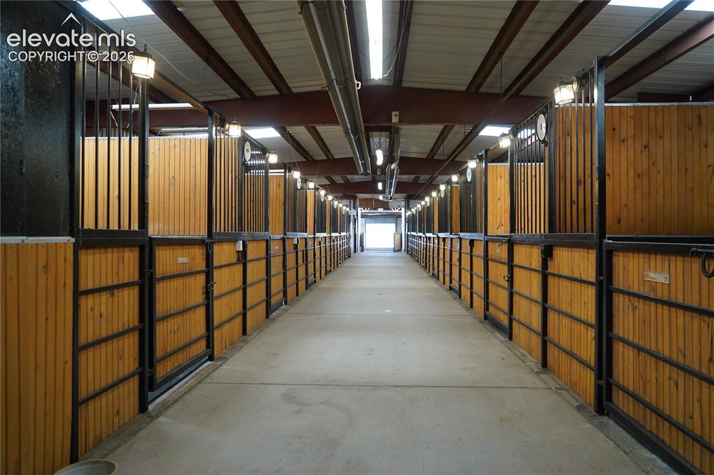 Image 29 of 41: Indoor facility featuring multiple stalls with wood paneling and black meta