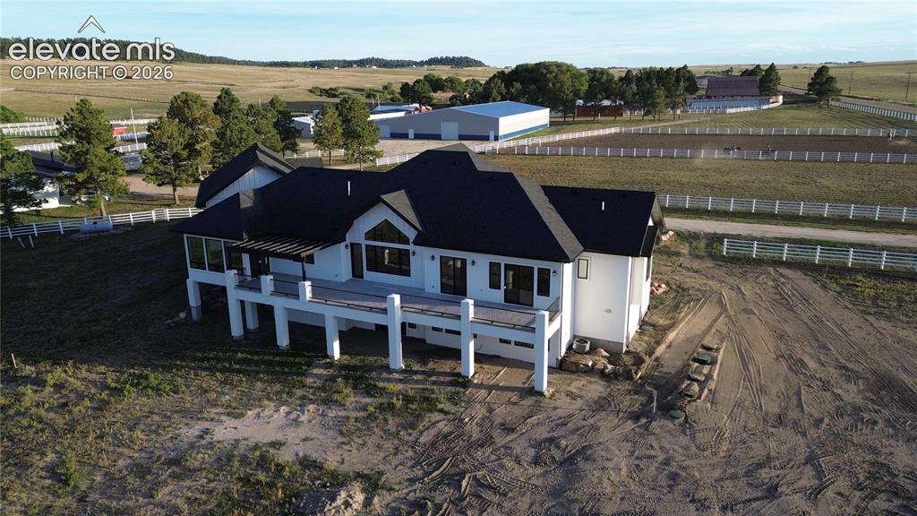 Image 7 of 41: Expansive property featuring a white exterior, dark shingled roof, and a la