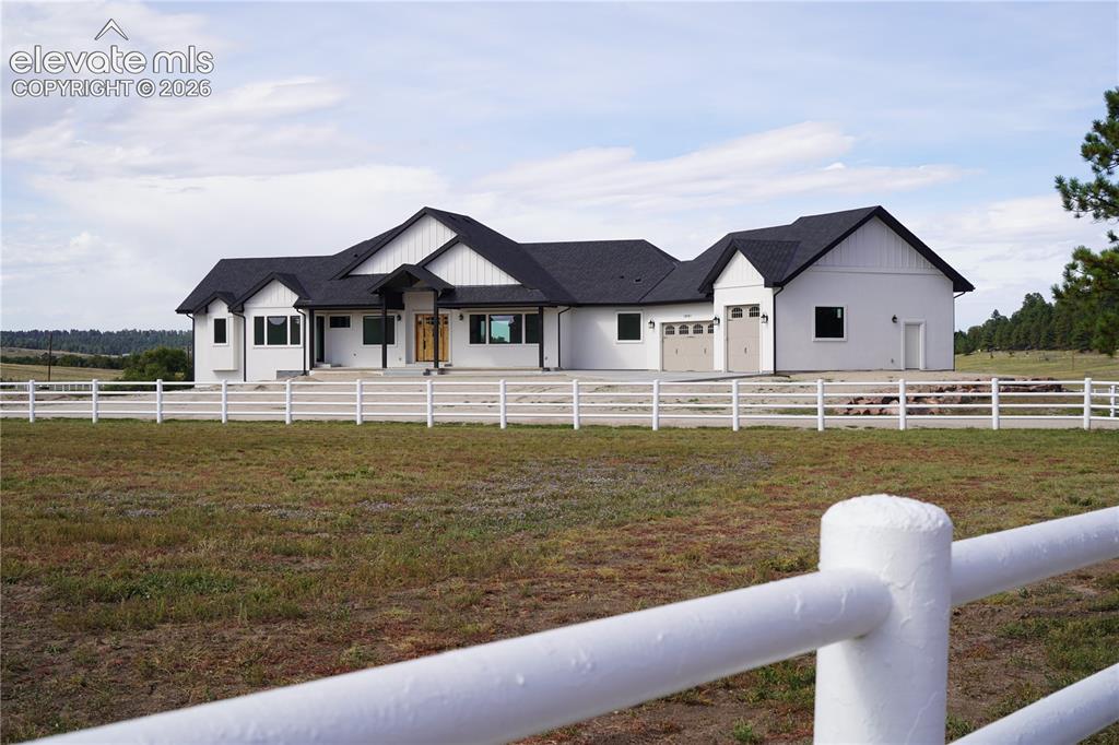 Image 8 of 41: White exterior with black trim, black shingle roof, attached two-car garage