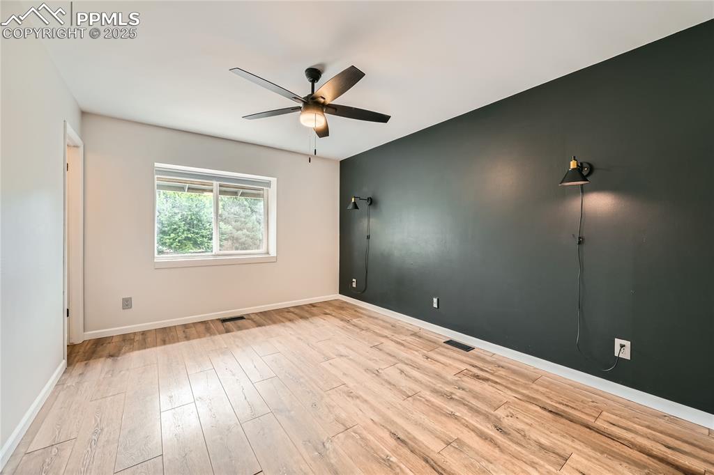 Image 11 of 32: room with a ceiling fan and wood finished floors