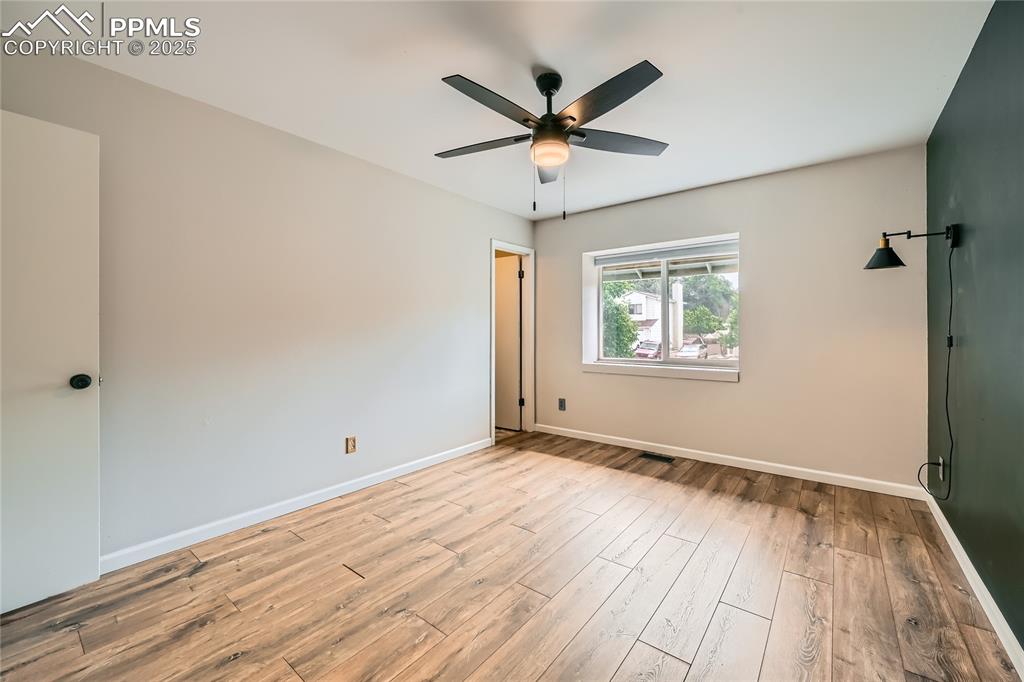Image 12 of 32: oom with wood finished floors and ceiling fan