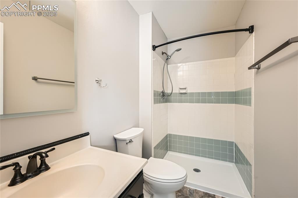 Image 14 of 32: Bathroom with a tile shower and vanity