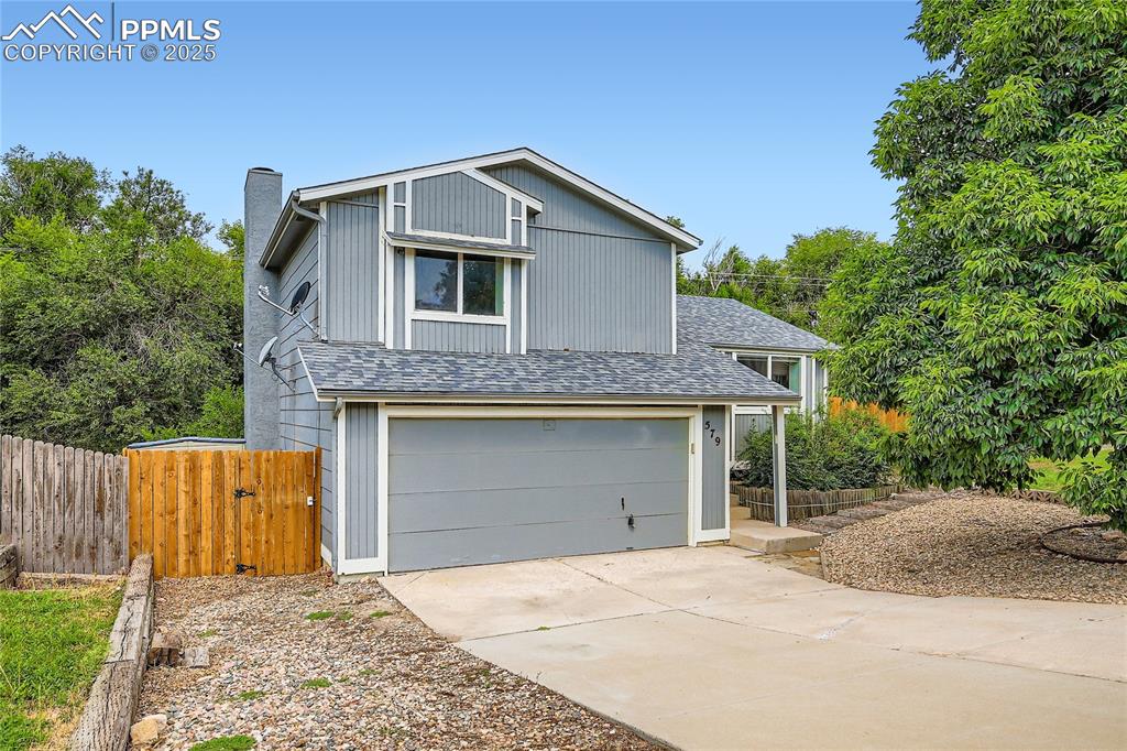 Image 2 of 32: View of front of property with a garage, roof with shingles, concrete drive