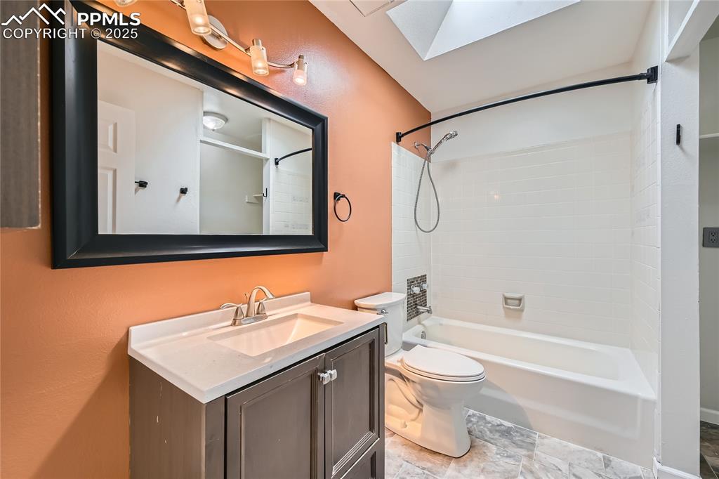 Image 20 of 32: Full bath with vanity, a skylight, and shower / washtub combination