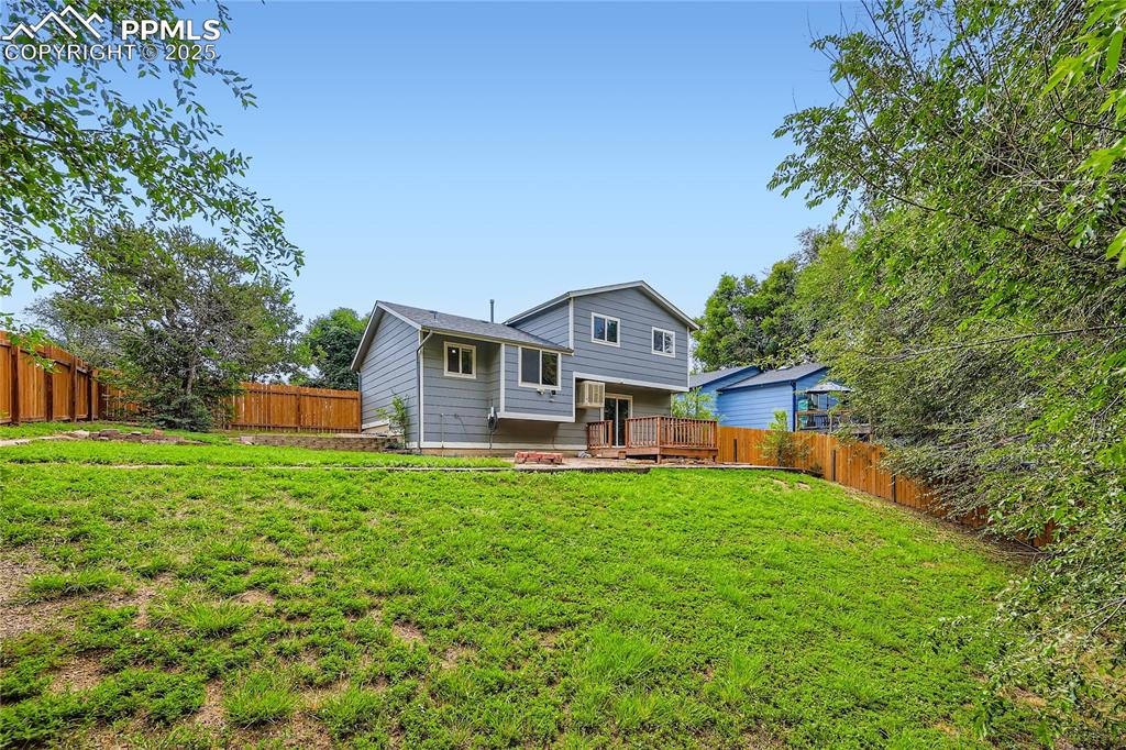 Image 27 of 32: Back of property with a fenced backyard and a deck