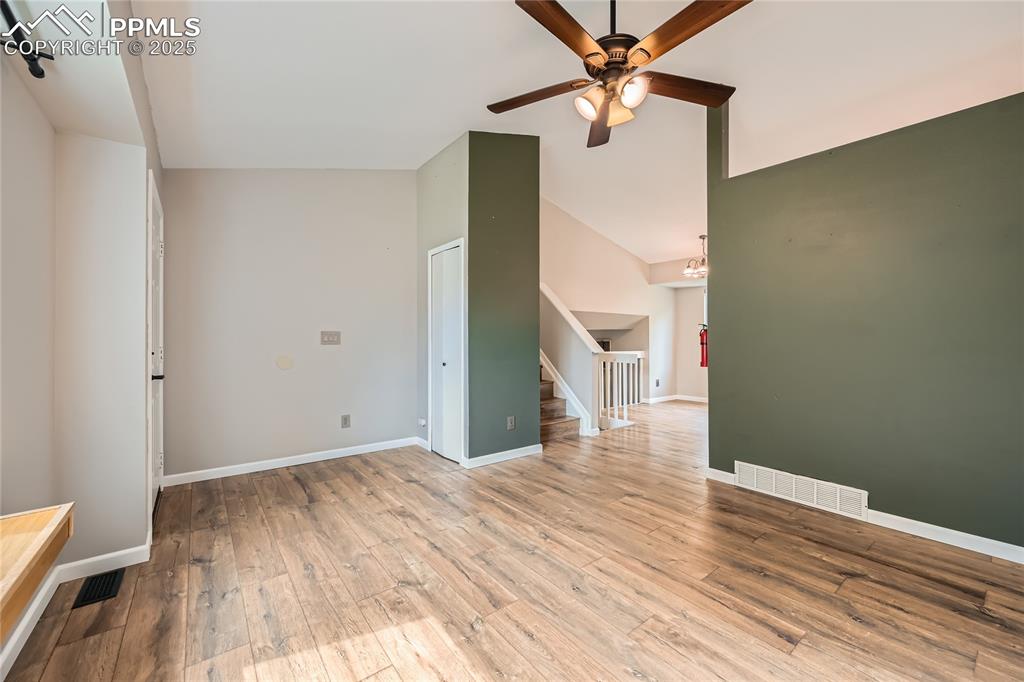 Image 6 of 32:  living room with lofted ceiling, a ceiling fan, wood finished floors, and 