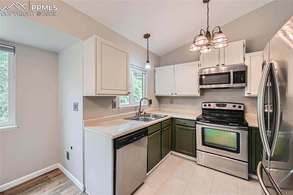 Image 7 of 32: Kitchen featuring appliances with stainless steel finishes, green cabinetry